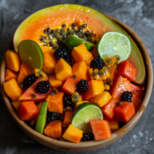 A Tropical Papaya Bowl bursting with goodness, featuring vibrant cubed papaya, juicy blackberries, and zesty lime slices. This nutritious bowl is topped with a halved papaya showcasing its fresh seeds and garnished with an extra lime slice. The vivid hues of these delicious fruits contrast beautifully against the dark, textured backdrop, highlighting the freshness and health benefits packed into every bite. Enjoy this eco-friendly delight from Zestful Blends - where health meets exquisite freshness.