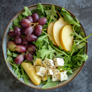 Discover the Asian Pear & Grape Salad from Zestful Blends — a masterpiece of vibrant, fresh ingredients bursting with goodness. This delightful medley features crisp arugula, juicy grape clusters, refreshing slices of Asian pear, and creamy cubes of feta cheese all perfectly accented with a hint of ground black pepper. Presented on a dark textured surface for an elegant touch, this salad not only looks stunning but also offers exceptional health benefits in every bite. Experience the freshness and eco-friendly ethos at Zestful Blends with every nutritious creation!