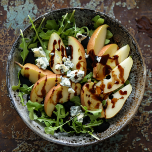 A vibrant bowl of fresh arugula bursting with goodness, topped with succulent slices of juicy pear and rich chunks of creamy blue cheese. Drizzled with a luscious balsamic glaze, our Pear & Blue Cheese Symphony is served on an eco-friendly, weathered metal surface that enhances its artisanal charm. Enjoy this refreshing and nutritious dish—a perfect blend of flavors that's as delightful to the palate as it is to the eye. Experience Zestful Blends: where health meets indulgence in every bite.