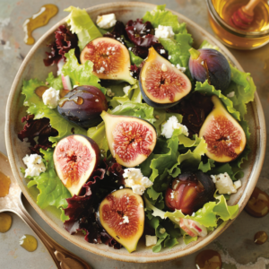 A vibrant bowl bursting with goodness, this Fig & Goat Cheese Delight showcases fresh greens, succulent halved figs, and creamy chunks of goat cheese drizzled with golden honey. Complemented by a wooden honey dipper and a small glass of organic honey in the background, this salad tantalizes your taste buds while offering a wholesome boost to your day. A wooden spoon lies gracefully on the side, emphasizing our commitment to eco-friendly choices. Indulge in the fresh flavors and health benefits that Zestful Blends proudly brings to your table!