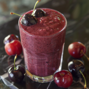 Experience the Zestful Blends Cherry Jubilee Smoothie, a glass brimming with dark purple, velvety goodness and topped with two plump, fresh cherries. Surrounded by an array of light and dark cherries, this invigorating smoothie is bursting with health benefits and natural freshness. Crafted for ultimate refreshment, each sip of our eco-friendly delight promises a harmonious blend of flavor and nutrition that will energize your day!