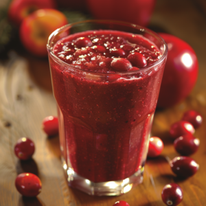 A vibrant Crimson Cranberry Crush Smoothie in a crystal-clear glass, garnished elegantly with whole cranberries. The scene is beautifully set with scattered cranberries and juicy red apples on a rustic wooden surface, radiating freshness. Bursting with goodness, our smoothie celebrates the health benefits of cranberries and apples. Relish in the natural flavors of Zestful Blends' offerings—deliciously fresh fruit salads, invigorating juices, wholesome snacks, nutrient-packed smoothies, delightful whole fruit packs, and delectable desserts—all crafted for your well-being and eco-friendly choice.