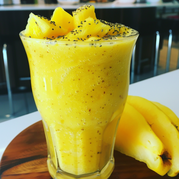 Discover pure vitality with our Pineapple Paradise Smoothie, a glass brimming with fresh, succulent pineapple chunks and nutrient-packed chia seeds that evoke an exotic taste of paradise. Beside it, a perfectly ripe banana invites you to embrace natural goodness. Set against the backdrop of a sleek, modern kitchen, this vibrant scene is not just about delicious flavor but also a commitment to eco-friendly choices and wholesome health benefits. At Zestful Blends, every sip and bite is bursting with goodness!